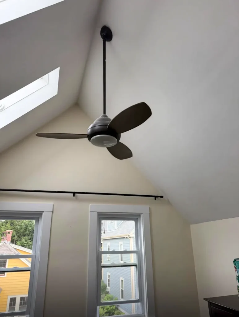 Black ceiling fan installed on a white vaulted ceiling