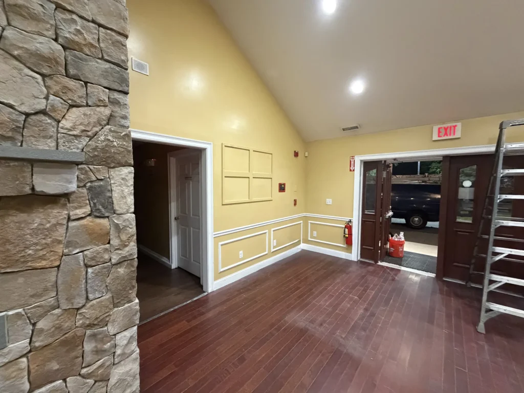 Commercial entry with wood flooring, stone accent wall, and white trim
