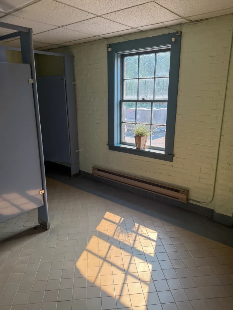 Interior room with tile flooring and a dark-trimmed window during renovation