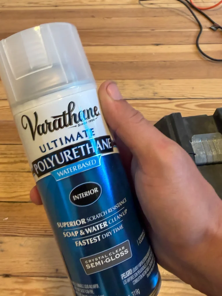 Can of water-based polyurethane held above a hardwood floor